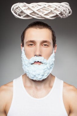 Cheerful bearded man is making fun during shaving