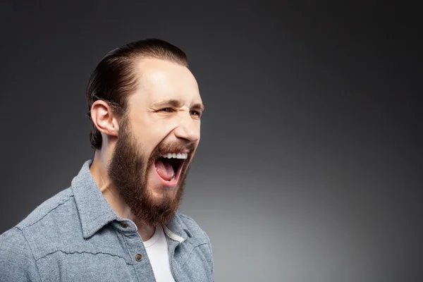 Cheerful young man with beard is expressing anger — Stok fotoğraf
