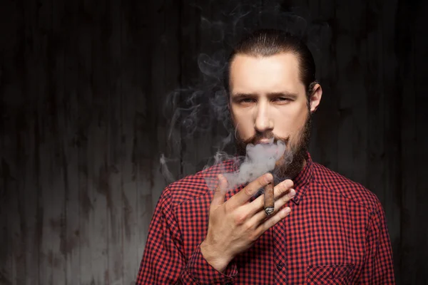 Atractivo joven barbudo hombre se relaja con el cigarrillo —  Fotos de Stock