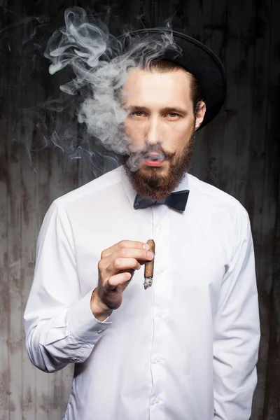 Guapo barbudo hipster chico con tapa y cigarrillo — Foto de Stock