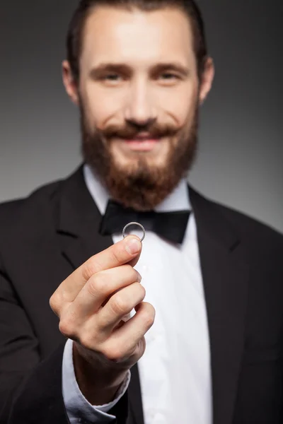 Attraktiver junger bärtiger Mann trägt Schmuck bei sich — Stockfoto