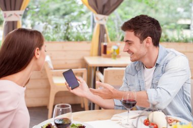Attractive young loving couple is dating in restaurant