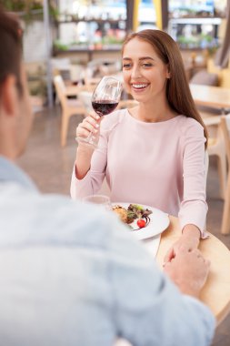 Cheerful young man and woman are resting in cafe