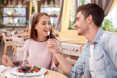 Cheerful boyfriend and girlfriend are resting in cafe