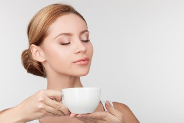 Cheerful healthy girl drinks tea with pleasure