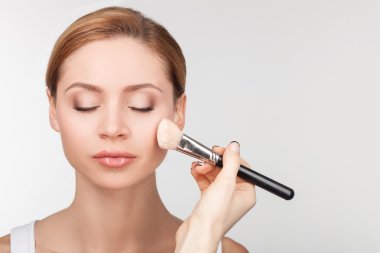 Beautiful young woman is treated by visagiste