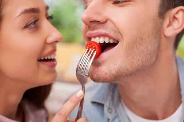 Cheerful young loving couple is eating in restaurant — Stockfoto