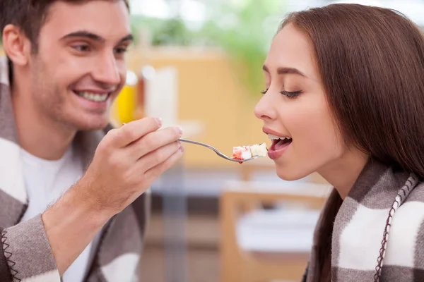 Beautiful young loving couple is eating in cafe — Stockfoto