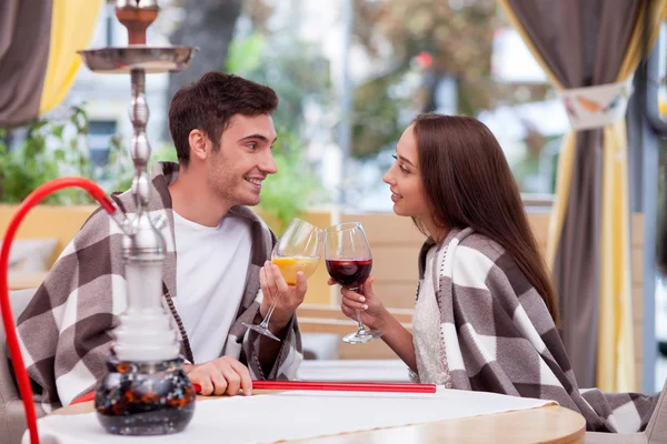Pretty loving couple is relaxing with water pipe in cafe — Stockfoto
