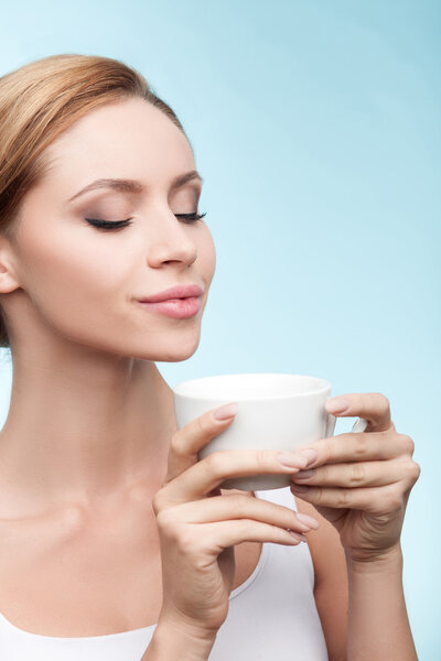Pretty healthy girl is enjoying hot tea