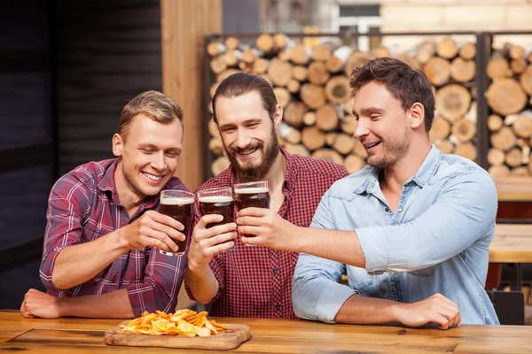 Knappe mannelijke vrienden genieten van lager in pub — Stockfoto