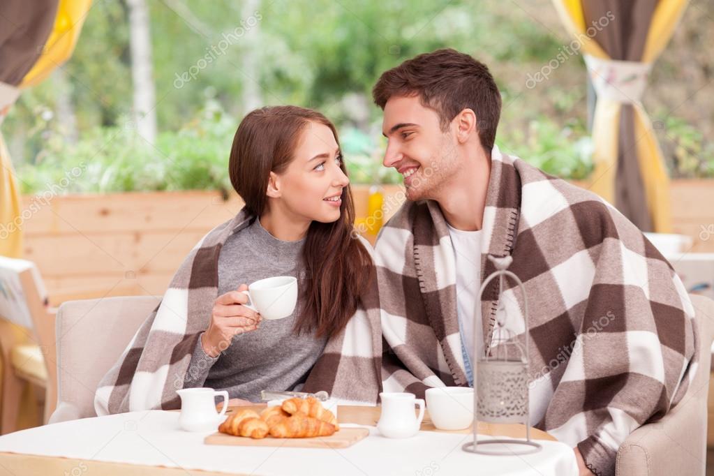Cheerful young loving couple is dating in cafe