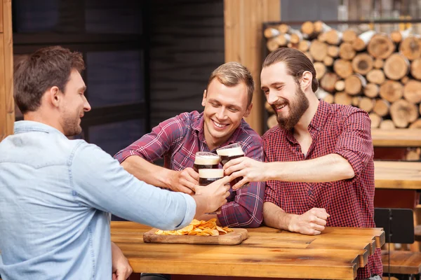 Vrolijke jonge mannen rusten in beerhouse — Stockfoto