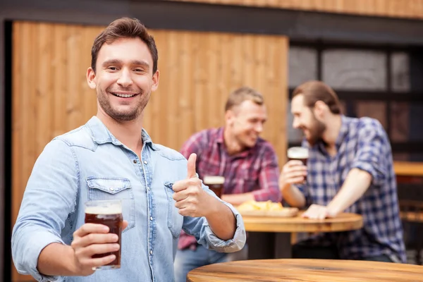 Attractive man is resting and gesturing in pub — Stock Photo, Image