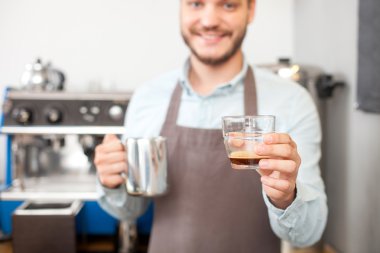 Yakışıklı genç barista kafeteryada kahve yapıyor