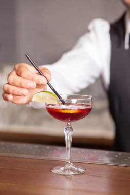 Skillful male bartender is preparing drink in pub