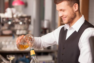 Cheerful young bartender is working in pub