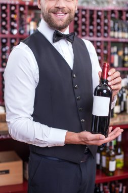 Handsome young waiter is working in liquor store