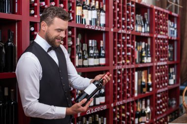 Attractive male sommelier is working in shop