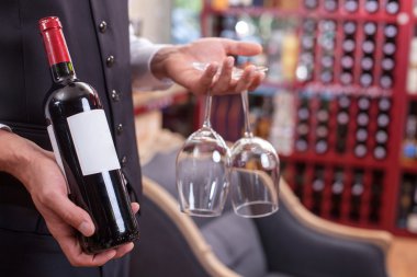 Skilled male sommelier is preparing wineglasses for drinking