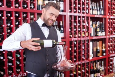 Attractive young waiter is working in liquor store