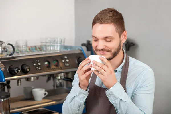 Guapo propietario de la cafetería está disfrutando de bebida caliente —  Fotos de Stock