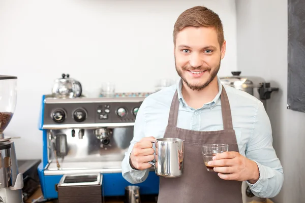 Attractive male owner of cafe is working with joy — Stock Photo, Image