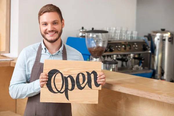 Attractive young worker is inviting in coffee shop — Stock Photo, Image