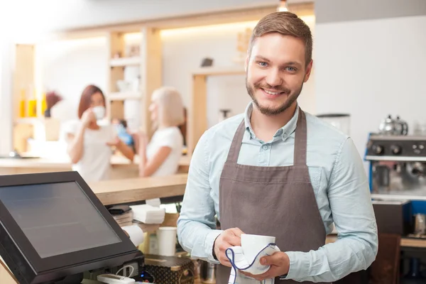 Pohledný mladý muž barista je mytí nádobí v kavárně — Stock fotografie