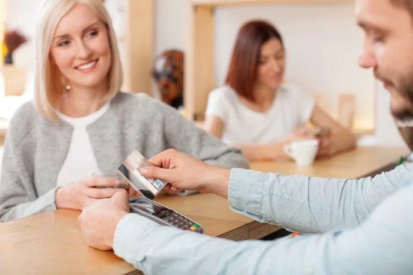 Attraente giovane barista maschio sta servendo il suo cliente — Foto Stock