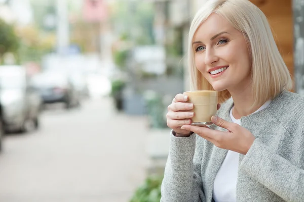 Atractiva chica rubia es relajante con taza de café con leche — Foto de Stock
