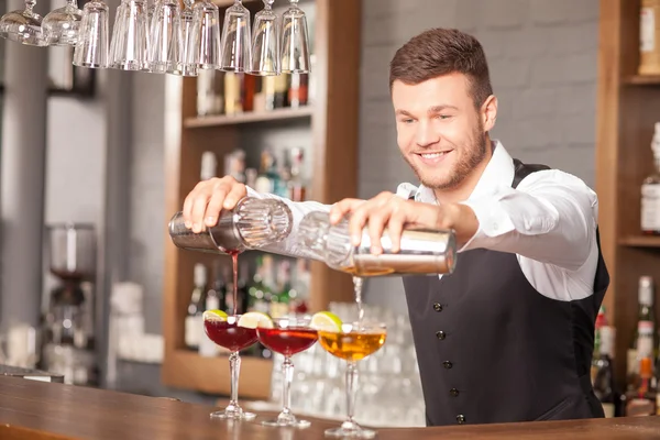 Attractive young barman is making drinks in pub — Stock Photo, Image