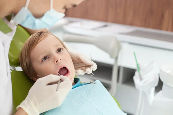 Médico dental joven profesional está tratando a paciente —  Fotos de Stock