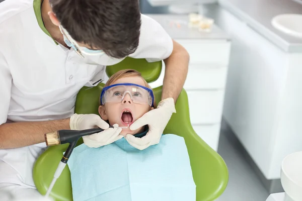 Profesional médico dental masculino está tratando a su paciente —  Fotos de Stock