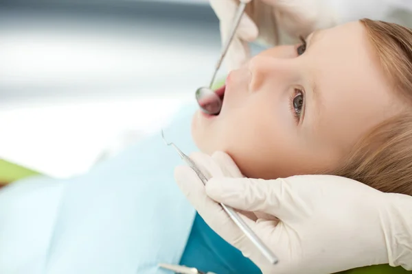Skilled dental doctor is examining oral cavity of child — 스톡 사진