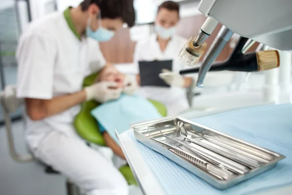 Médico dental joven profesional está tratando a paciente — Foto de Stock