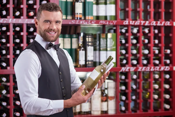 Cheerful male waiter is working in wine-cellar — ストック写真