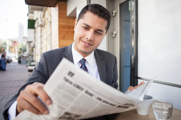 Guapo joven con traje está descansando en la cafetería — Foto de Stock