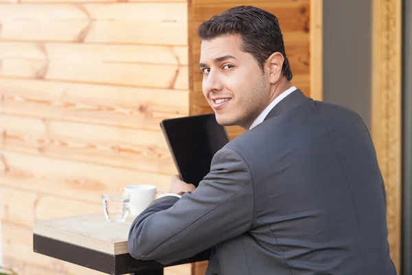 Alegre trabajador masculino está utilizando el ordenador portátil en la cafetería — Foto de Stock