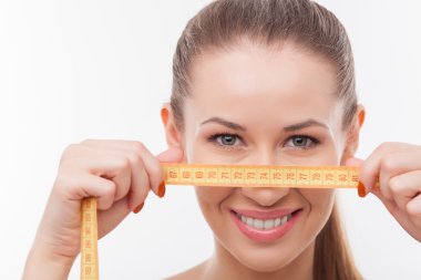 Attractive young fit girl with tape measure
