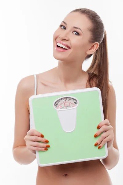 Cheerful young woman is carrying weighing machine — Φωτογραφία Αρχείου