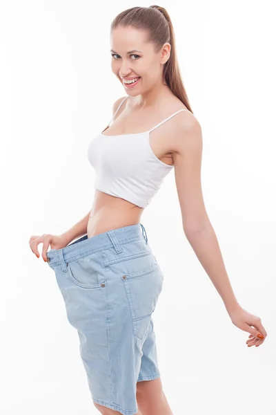 Cheerful slim girl with big blue trousers — Stock Photo, Image