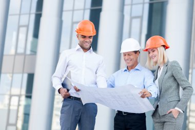 Cheerful three builders are planning new project