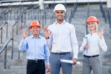 Skillful construction team is gesturing with positive emotions