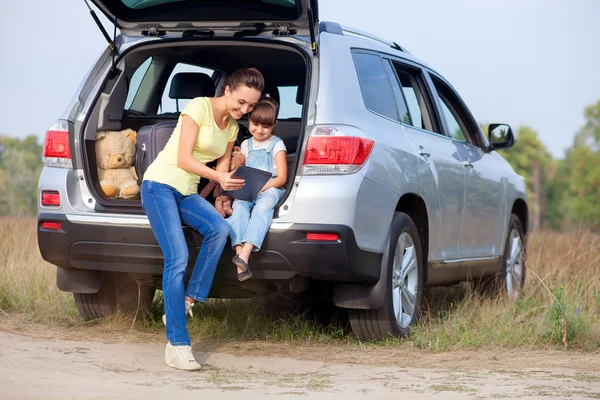 Mujer linda con niño en la naturaleza cerca del transporte — Foto de Stock