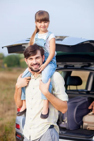 Bonito pai masculino e criança no prado perto do carro — Fotografia de Stock
