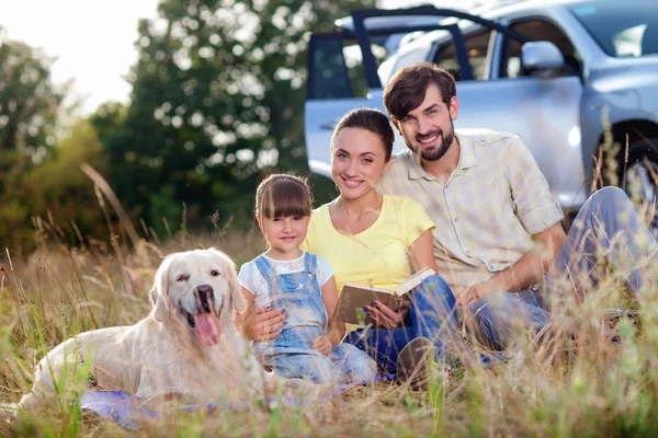 Веселые родители и ребенок с домашним животным в поездке — стоковое фото
