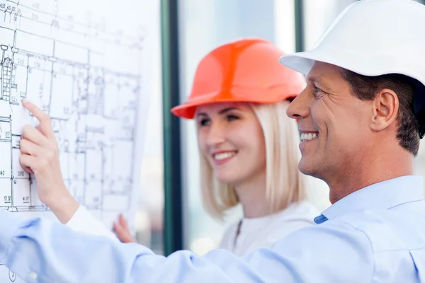Cheerful engineers are discussing plan of building — 스톡 사진