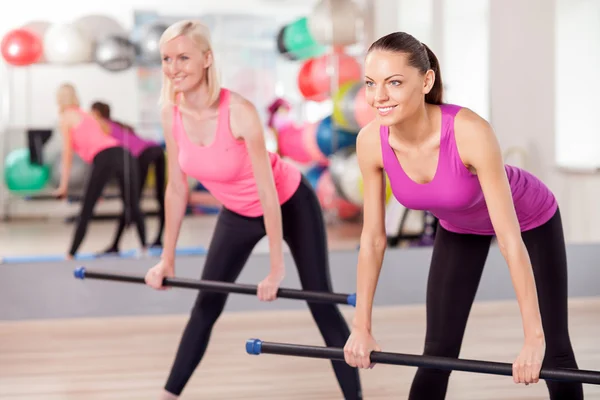 Atractivas mujeres jóvenes están haciendo ejercicio en el gimnasio — Foto de Stock