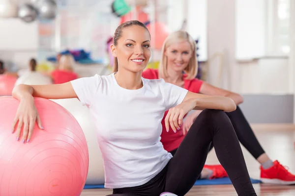 Cute slim girls are exercising in fitness center — Stock Photo, Image